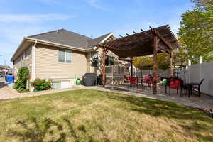 Back of property featuring a pergola, a patio, and roof with shingles