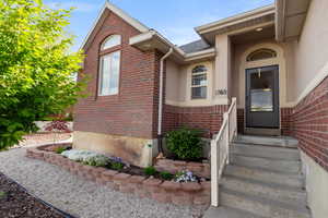 Doorway to property with brick siding and stucco siding