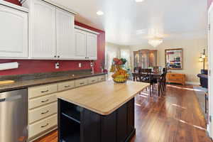 Kitchen featuring stainless steel appliances, dark wood-style floors, wood counters, a chandelier, and a kitchen island