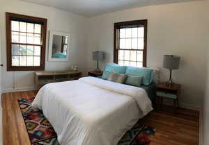 Bedroom with wood finished floors and baseboards
