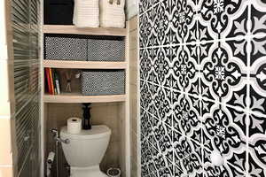 Bathroom with toilet and tile walls