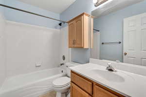 Bathroom with toilet, tub / shower combination, and vanity