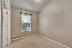 Unfurnished room featuring light colored carpet and baseboards