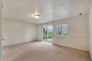 Empty room featuring baseboards and light carpet