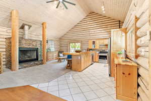 Kitchen with wood counters, rustic walls, updated stainless steel appliances, and light cabinetry.