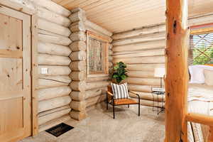 Spacious primary bedroom with log walls