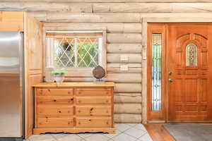 Foyer entrance with rustic log walls and charming windows.