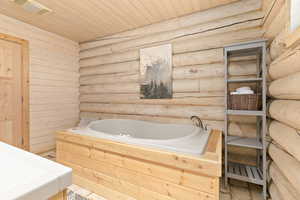 Bath featuring log walls, jetted tub, and separate shower