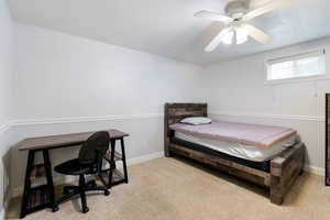 Bedroom featuring baseboards, a ceiling fan, carpet floors, and a desk