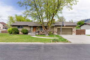 Ranch-style house featuring stone siding, a garage, driveway, and a shingled roof