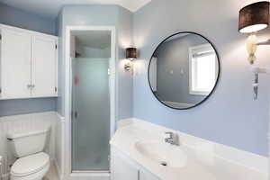 Full bathroom with a shower stall, toilet, tile patterned flooring, and vanity