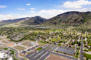 Aerial view of property and surrounding area with a mountainous background and nearby suburban area