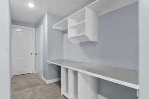 Hallway with desk leading toward basement bathroom and bedroom