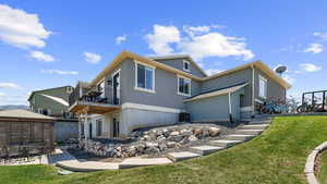 Rear view of house with a lawn, stucco siding, a patio, and a balcony