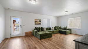 Living room featuring light wood-style floors and baseboards