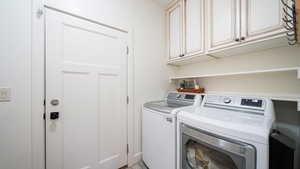 Laundry area featuring washer and dryer and cabinet space
