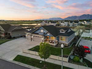 Craftsman house featuring stone siding, a mountain view, a garage, driveway, and a residential view