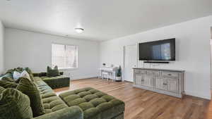 Living area featuring light wood-style floors and baseboards