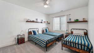 Carpeted bedroom featuring baseboards and a ceiling fan