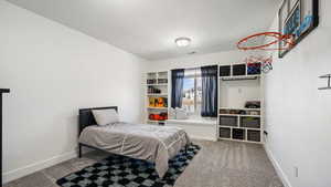 Bedroom featuring carpet floors, baseboards, and a textured ceiling