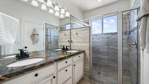 Bathroom featuring a stall shower and double vanity