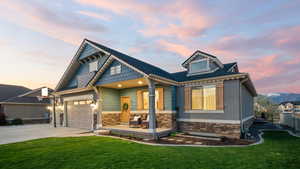 View of front of house featuring concrete driveway, a porch, stone siding, and an attached garage