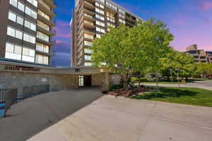 Property at dusk with concrete driveway and a carport