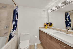 Full bath featuring toilet, vanity, tile patterned floors, and tiled shower / bath