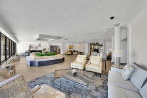 Living room with healthy amount of natural light, a textured ceiling, a chandelier, and wood finished floors