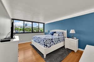 Bedroom featuring wood finished floors, baseboards, and a textured ceiling