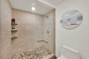 Full bath with toilet and tiled shower