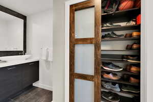 Bathroom featuring vanity, wood finished floors, and baseboards