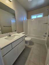Full bathroom featuring bathtub / shower combination, toilet, vanity, and tile patterned floors