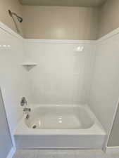Full bath featuring tile patterned flooring, bathing tub / shower combination, and baseboards