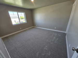 Carpeted empty room with baseboards and a textured ceiling
