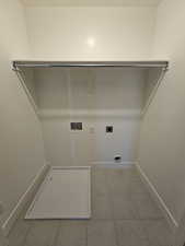 Laundry area with electric dryer hookup, washer hookup, baseboards, and light tile patterned floors