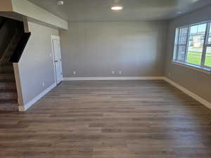 Unfurnished room with stairs, baseboards, recessed lighting, dark wood-style flooring, and a smoke detector