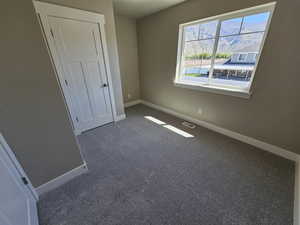 Unfurnished bedroom featuring baseboards and carpet floors