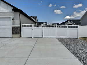 View of patio / terrace with fence, a gate, and a garage