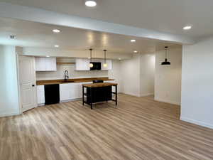 Kitchen with black appliances, wooden counters, baseboards, recessed lighting, and light wood finished floors