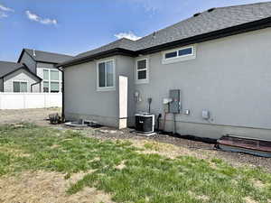 Back of property with central AC unit and stucco siding