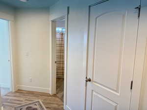 Corridor featuring light wood-style floors and baseboards