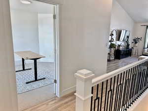 Corridor with wood finished floors, an upstairs landing, and baseboards