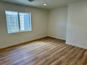 Spare room with wood finished floors, baseboards, and recessed lighting