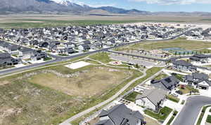 Aerial view of property and surrounding area featuring nearby suburban area and mountains