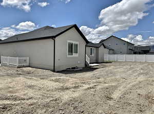 Back of house with fence and stucco siding