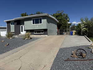 Split foyer home featuring fence, driveway, and a gate