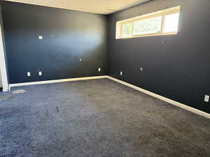 Carpeted spare room with baseboards and a textured ceiling
