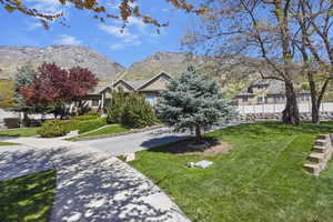 View of front facade with front lawn, driveway and mountain view