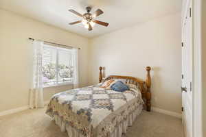 Bedroom featuring baseboards, carpet flooring, and a ceiling fan